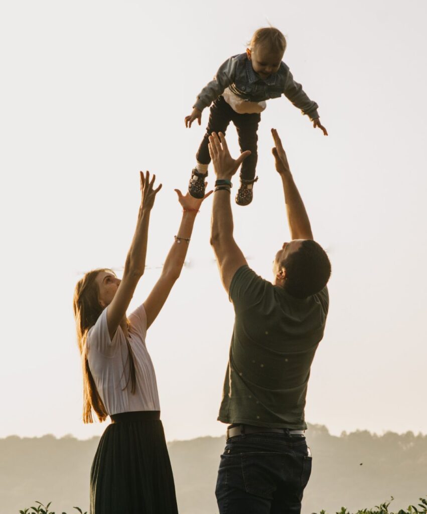 happy family in integrative wellness coaching throwing their baby in the air